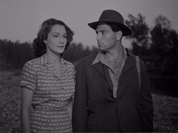 Movie still from “Bitter Rice” (1949), directed by Giuseppe De Santis – A man and a woman standing next to each other; Medium shot, Low angle