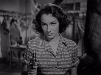 Movie still from “Bitter Rice” (1949), directed by Giuseppe De Santis – A black and white photo of a woman holding a gun; Close Up shot, Low angle