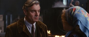 Movie still from “Black Book” (2006), directed by Paul Verhoeven – An older man wearing a suit and a tie; Close Up shot, Over the shoulder angle