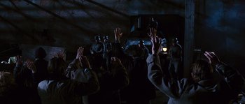 Movie still from “Black Book” (2006), directed by Paul Verhoeven – A group of people in a dark room raising their hands in the air; Wide shot, High angle