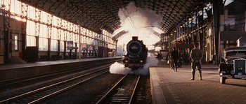 Movie still from “Black Book” (2006), directed by Paul Verhoeven – A train is coming down the tracks at a train station; Extreme Wide shot, Low angle