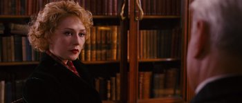 Movie still from “Black Book” (2006), directed by Paul Verhoeven – A woman standing in front of a bookcase in a library; Close Up shot, Over the shoulder angle