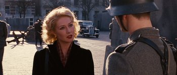 Movie still from “Black Book” (2006), directed by Paul Verhoeven – A woman talking to a man in a suit and tie; Close Up shot, Over the shoulder angle