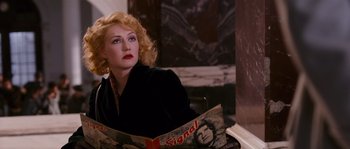 Movie still from “Black Book” (2006), directed by Paul Verhoeven – A woman sitting in a chair reading a magazine; Medium shot, Over the shoulder angle