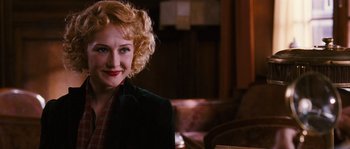 Movie still from “Black Book” (2006), directed by Paul Verhoeven – A woman with blonde hair and a red lipstick is smiling for the camera; Close Up shot, Over the shoulder angle