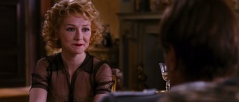 Movie still from “Black Book” (2006), directed by Paul Verhoeven – A woman sitting at a table with a glass of wine in front of her; Close Up shot, Over the shoulder angle