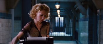 Movie still from “Black Book” (2006), directed by Paul Verhoeven – A woman is writing on a piece of paper in a dark room; Medium shot, Low angle