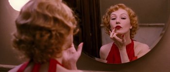 Movie still from “Black Book” (2006), directed by Paul Verhoeven – A woman in a red dress looking in the mirror; Close Up shot, Over the shoulder angle
