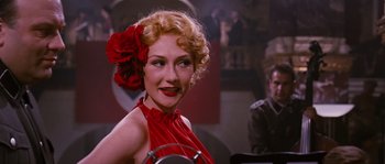 Movie still from “Black Book” (2006), directed by Paul Verhoeven – A woman in a red dress with a flower in her hair; Close Up shot, Low angle