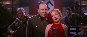 Movie still from “Black Book” (2006), directed by Paul Verhoeven – A man and a woman are posing for a picture; Medium shot, Low angle