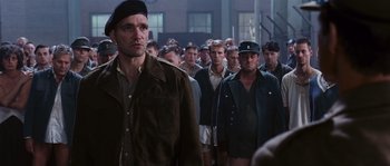 Movie still from “Black Book” (2006), directed by Paul Verhoeven – A group of men standing next to each other in front of a building; Medium shot, Over the shoulder angle