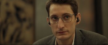Movie still from “Black Box” (2021), directed by Yann Gozlan – A person wearing glasses; Close Up shot, Over the shoulder angle
