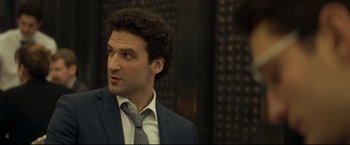 Movie still from “Black Box” (2021), directed by Yann Gozlan – A person wearing a suit and tie; Close Up shot, Over the shoulder angle