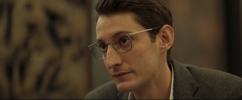 Movie still from “Black Box” (2021), directed by Yann Gozlan – A person wearing glasses; Close Up shot, Over the shoulder angle