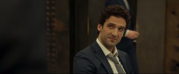 Movie still from “Black Box” (2021), directed by Yann Gozlan – A person wearing a suit and tie; Close Up shot, Over the shoulder angle
