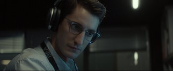Movie still from “Black Box” (2021), directed by Yann Gozlan – A person wearing headphones and glasses; Close Up shot, Low angle