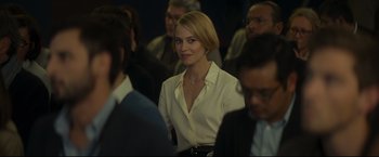 Movie still from “Black Box” (2021), directed by Yann Gozlan – A woman in a white shirt is in a crowd of people; Close Up shot, Over the shoulder angle