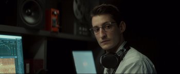 Movie still from “Black Box” (2021), directed by Yann Gozlan – A young man wearing glasses and headphones looking at the camera; Close Up shot, Low angle