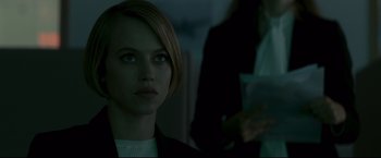 Movie still from “Black Box” (2021), directed by Yann Gozlan – A woman with short blonde hair is looking into the distance; Close Up shot, Over the shoulder angle