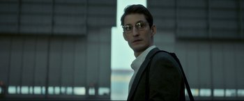 Movie still from “Black Box” (2021), directed by Yann Gozlan – A man wearing glasses and a suit; Close Up shot, Low angle