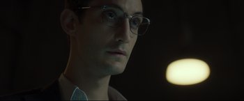 Movie still from “Black Box” (2021), directed by Yann Gozlan – A person wearing glasses; Close Up shot, Low angle