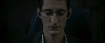 Movie still from “Black Box” (2021), directed by Yann Gozlan – A person wearing glasses with his eyes closed; Close Up shot, High angle