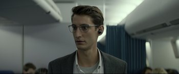 Movie still from “Black Box” (2021), directed by Yann Gozlan – A man wearing glasses and a jacket; Close Up shot, Over the shoulder angle