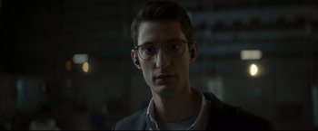 Movie still from “Black Box” (2021), directed by Yann Gozlan – A young man wearing glasses and a white shirt; Close Up shot, Over the shoulder angle
