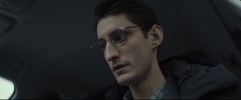 Movie still from “Black Box” (2021), directed by Yann Gozlan – A person wearing glasses and a jacket; Close Up shot, Low angle