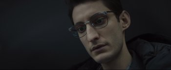 Movie still from “Black Box” (2021), directed by Yann Gozlan – A person wearing glasses; Close Up shot, Low angle