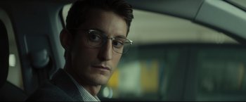 Movie still from “Black Box” (2021), directed by Yann Gozlan – A person wearing glasses; Close Up shot, Over the shoulder angle