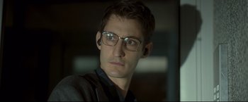 Movie still from “Black Box” (2021), directed by Yann Gozlan – A person wearing glasses; Close Up shot, Low angle