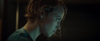 Movie still from “Black Box” (2021), directed by Yann Gozlan – A woman's face in the dark; Close Up shot, Low angle