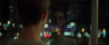Movie still from “Black Box” (2021), directed by Yann Gozlan – A man with glasses is looking at his reflection in a mirror; Close Up shot, Over the shoulder angle