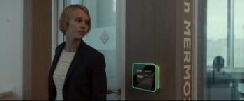 Movie still from “Black Box” (2021), directed by Yann Gozlan – A woman standing in front of a wall with an alarm clock on it; Medium shot, Over the shoulder angle