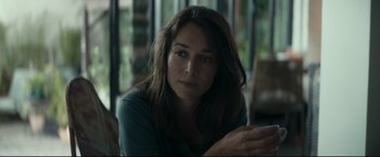 Movie still from “Black Box” (2021), directed by Yann Gozlan – A person sitting at a table; Close Up shot, Over the shoulder angle