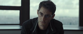 Movie still from “Black Box” (2021), directed by Yann Gozlan – A person wearing glasses and a jacket; Close Up shot, Over the shoulder angle