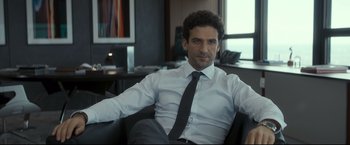 Movie still from “Black Box” (2021), directed by Yann Gozlan – A person sitting in a chair wearing a shirt and tie; Medium shot, Low angle