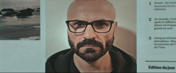 Movie still from “Black Box” (2021), directed by Yann Gozlan – A man with a bald head wearing glasses and a black shirt; Extreme Close Up shot, Low angle