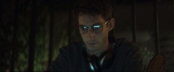 Movie still from “Black Box” (2021), directed by Yann Gozlan – A man with glasses and headphones looking at the camera; Close Up shot, Low angle