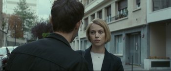Movie still from “Black Box” (2021), directed by Yann Gozlan – A man and a woman standing next to each other on the street; Close Up shot, Over the shoulder angle