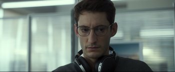 Movie still from “Black Box” (2021), directed by Yann Gozlan – A person wearing headphones and glasses; Close Up shot, Low angle