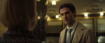 Movie still from “Black Box” (2021), directed by Yann Gozlan – A man wearing a suit and tie in front of a mirror; Close Up shot, Over the shoulder angle