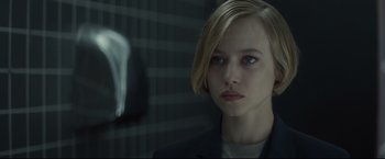 Movie still from “Black Box” (2021), directed by Yann Gozlan – A woman with short blonde hair wearing a black jacket; Close Up shot, Over the shoulder angle
