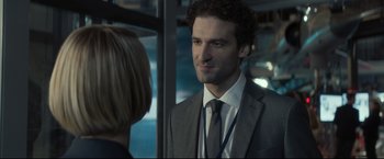 Movie still from “Black Box” (2021), directed by Yann Gozlan – A man wearing a suit and tie standing next to a woman; Close Up shot, Over the shoulder angle
