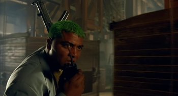 Movie still from “Black Cat, White Cat” (1998), directed by Emir Kusturica – A man with green hair is smoking a cigarette; Medium shot, Low angle