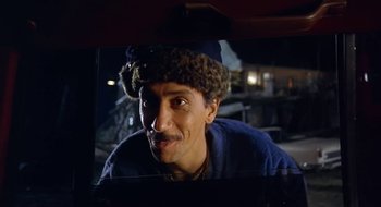 Movie still from “Black Cat, White Cat” (1998), directed by Emir Kusturica – A man wearing a blue shirt and a blue hat; Close Up shot, Low angle