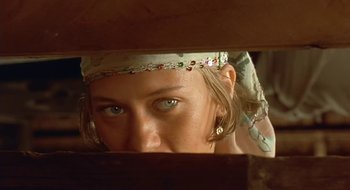 Movie still from “Black Cat, White Cat” (1998), directed by Emir Kusturica – A person wearing a head scarf; Close Up shot, Low angle