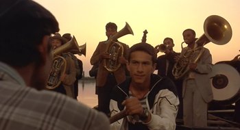 Movie still from “Black Cat, White Cat” (1998), directed by Emir Kusturica – A group of men standing next to each other with brass instruments; Medium shot, Low angle
