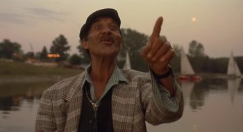 Movie still from “Black Cat, White Cat” (1998), directed by Emir Kusturica – An older man pointing up at the sky; Close Up shot, Low angle
